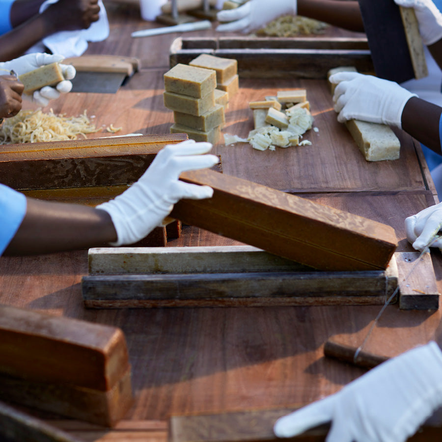 View of Mwani Zanzibar Mamas crafting soap bars at table.